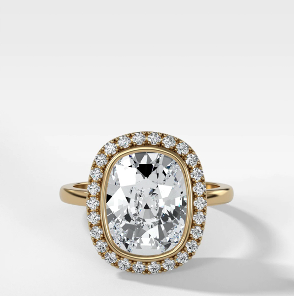 A picture of a halo setting with an elongated cushion cut diamond in the center