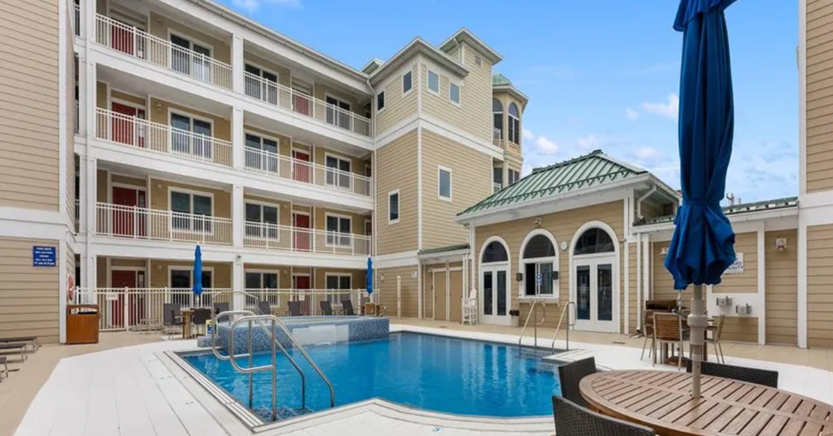 The Pointe at Moores Inlet courtyard pool in North Wildwood, featuring a heated swimming pool, lounge seating, and the condo building’s exterior with balconies and coastal architecture.