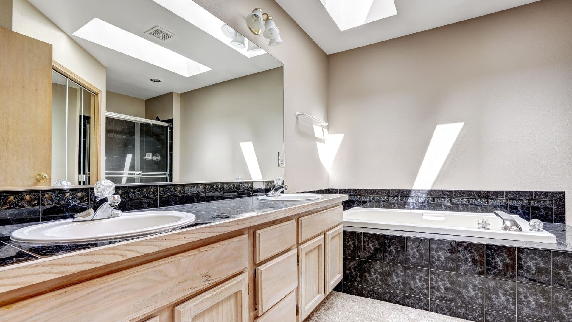 Elegant bathroom with oak cabinets, and tub