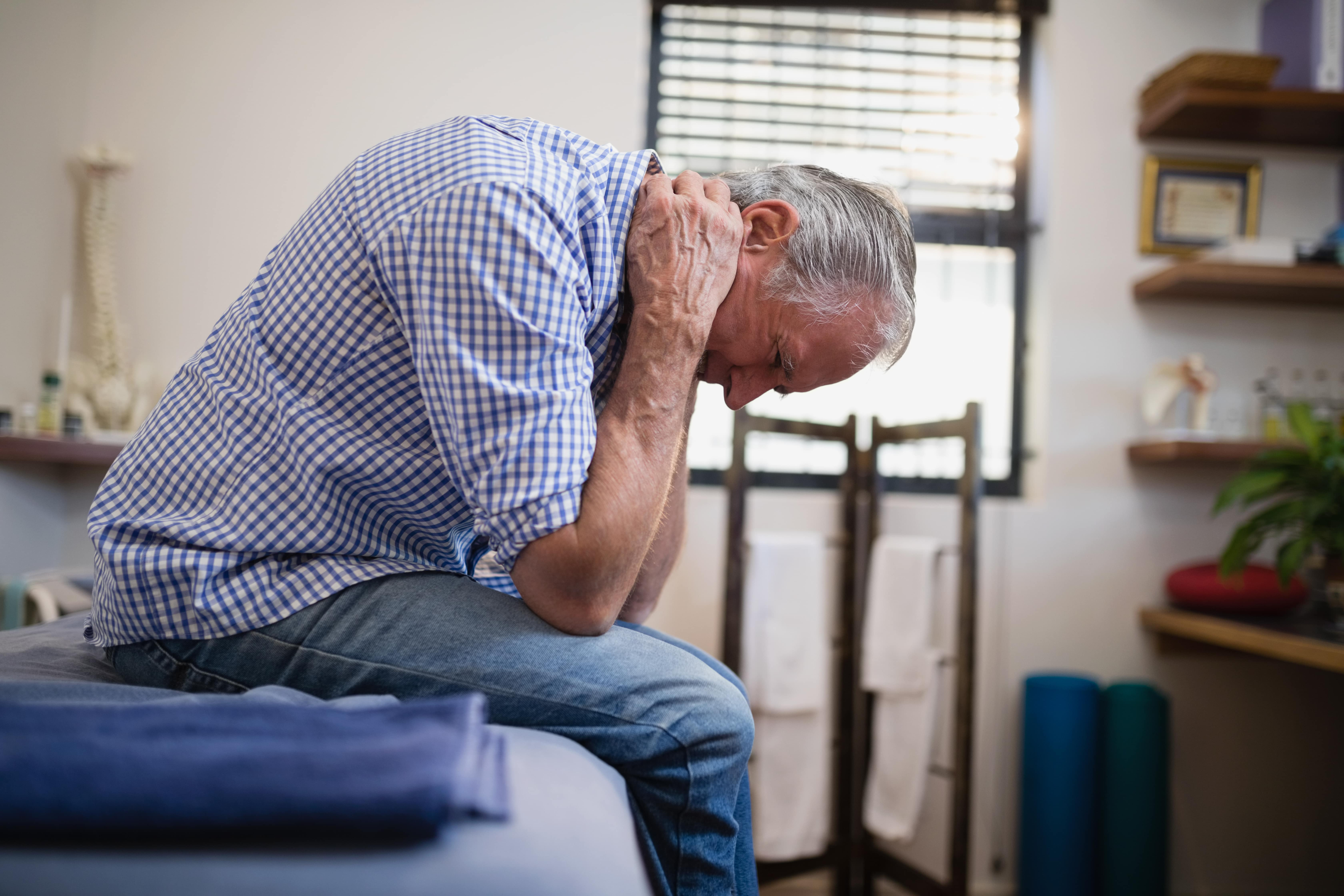 older man leaning forward in pain