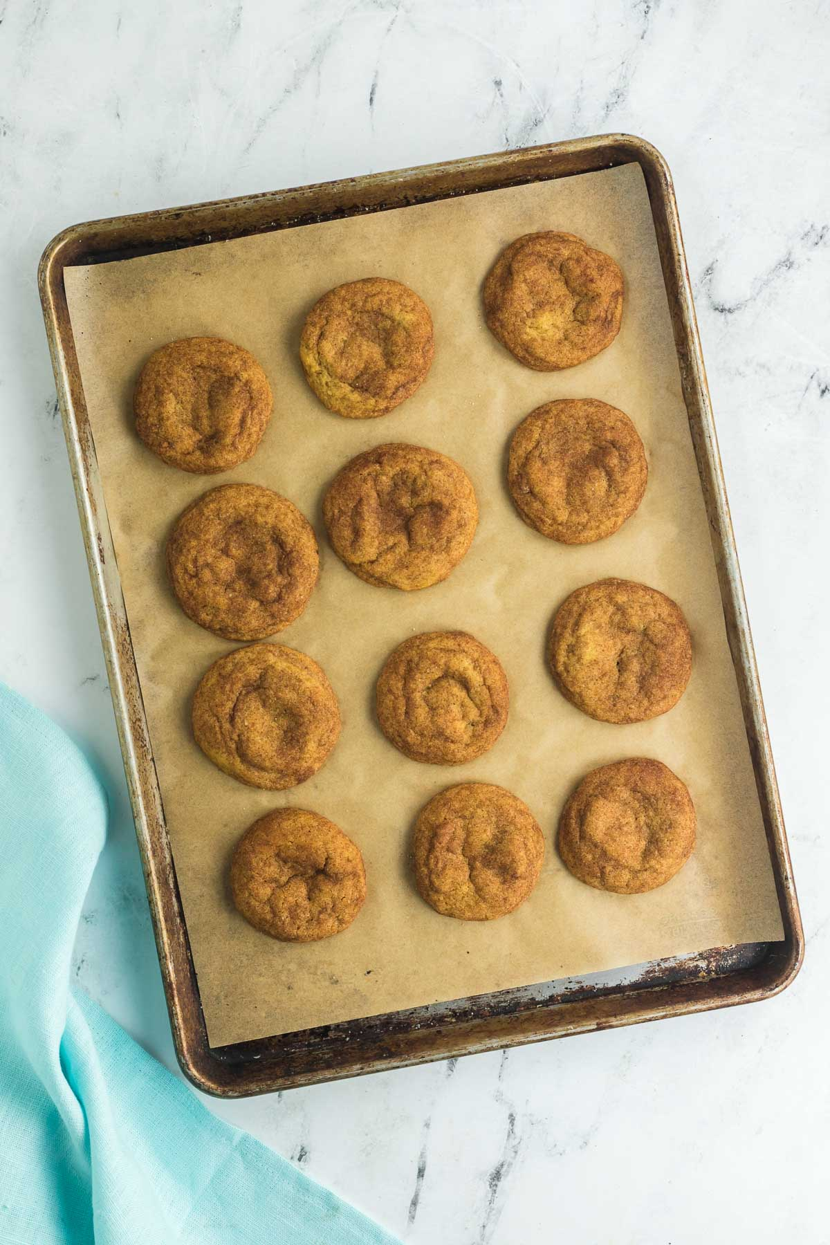 a dozen baked brown butter pumpkin spice cookies on a cookie sheet