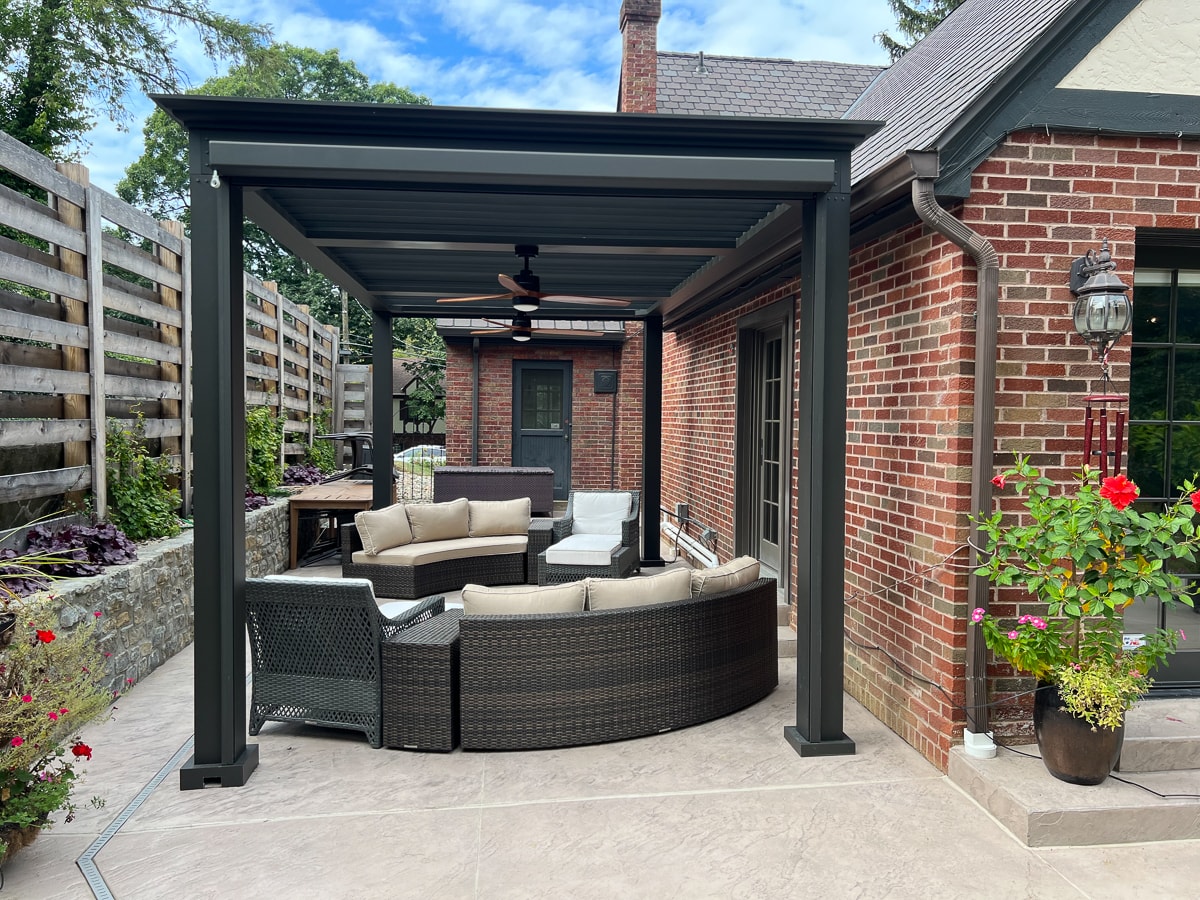 Freestanding pergola with outdoor seating installed over a patio.