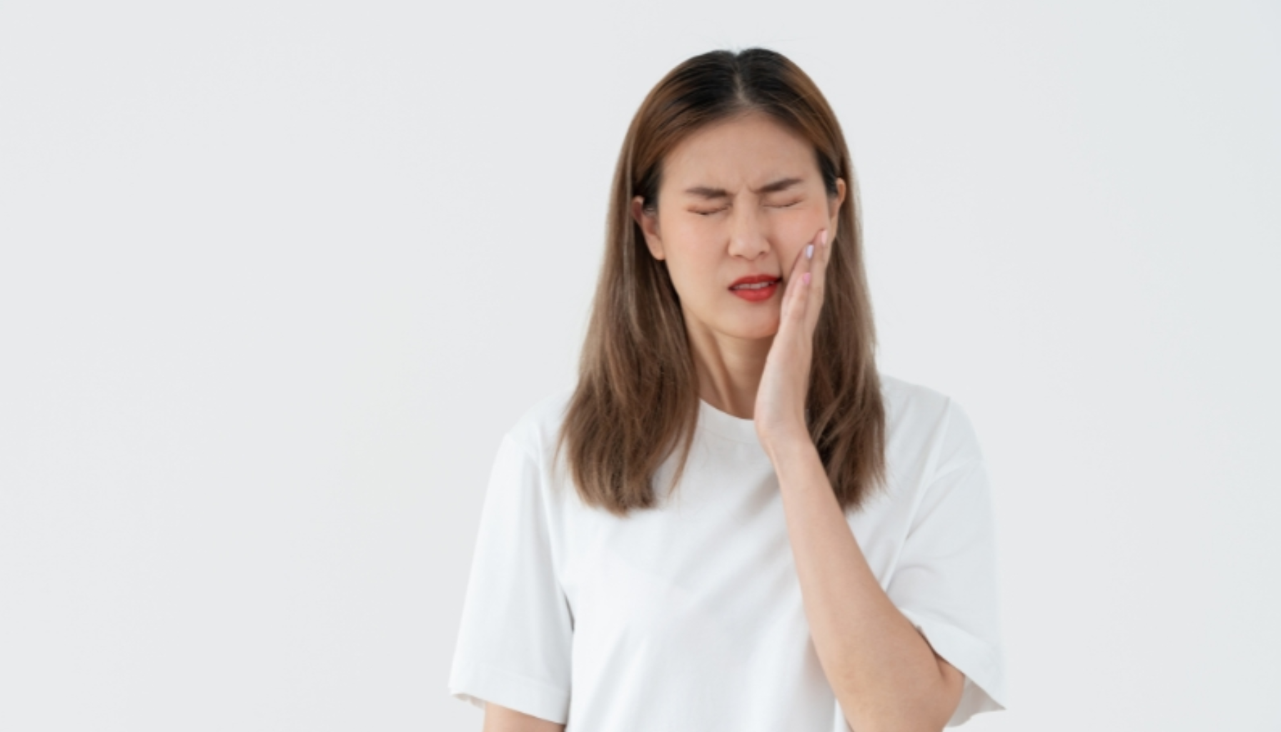 Tannbetennelse: Den Skjulte Infeksjonen Som Kan Ødelegge Mer Enn Bare Tanna 18 Ung kvinne med smerteuttrykk holder seg til kinnet på grunn av tannpine.