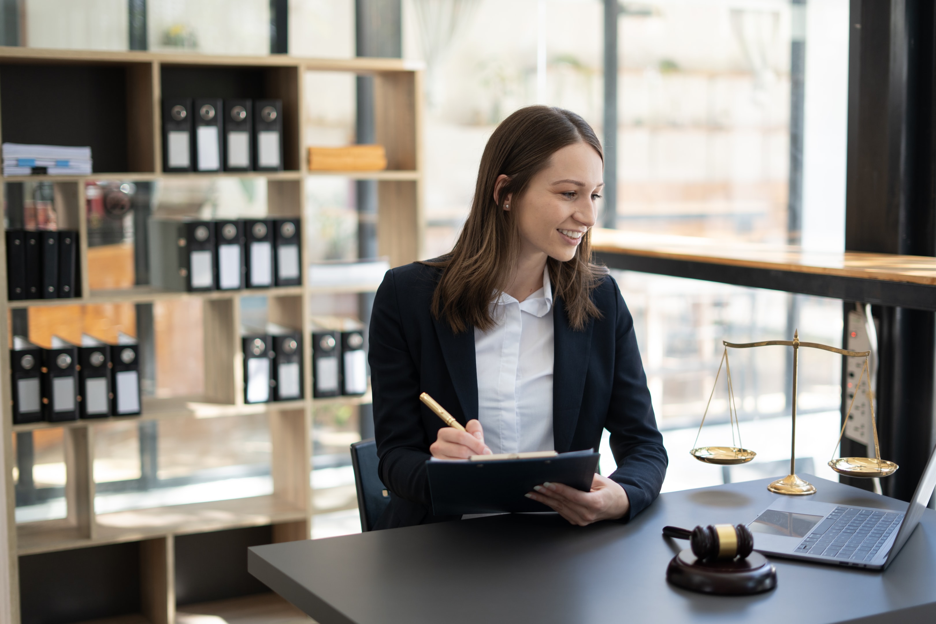 Woman legal services working on a laptop for business law and criminal law. Legal law, free initial consultation and justice concept.