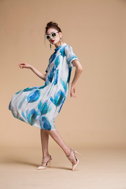 model wearing sunglasses with white dress with blue flowers