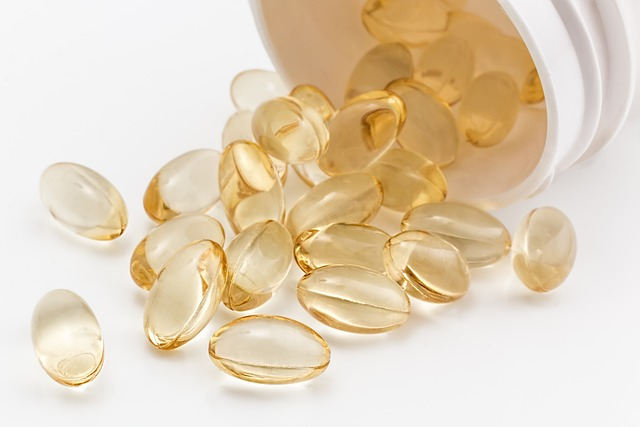 An image of gel capsules spilling out of a pill bottle onto a table. 