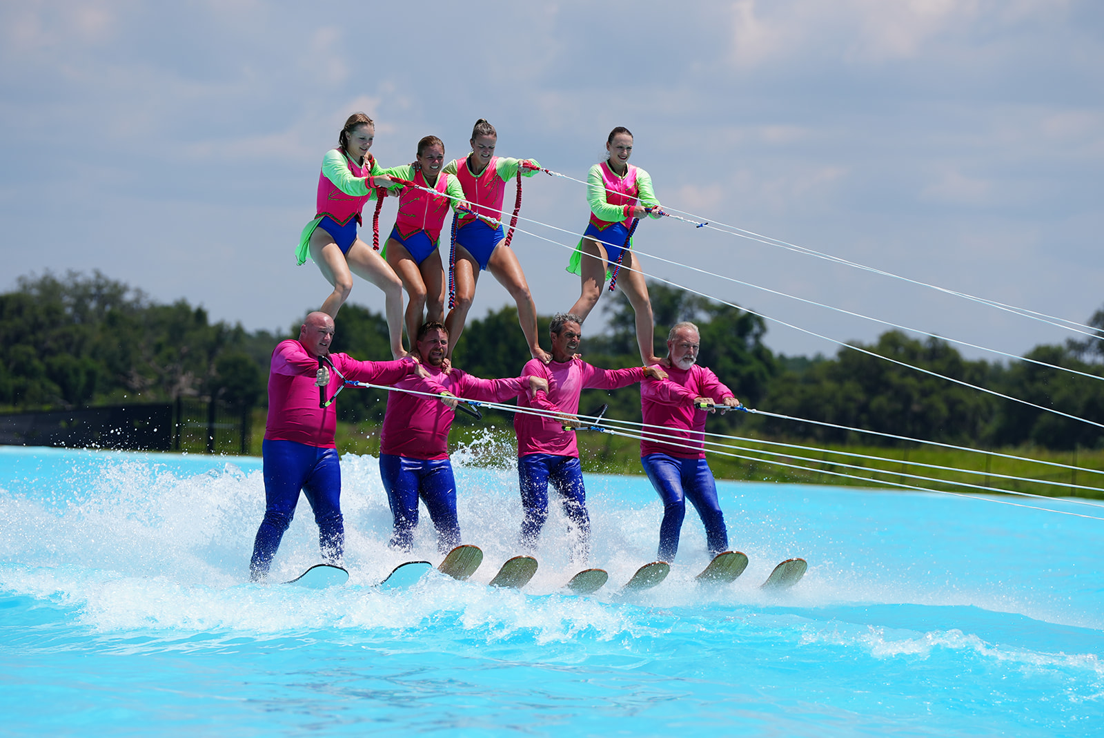 Water skiers stack up in a pyramid on the water 
