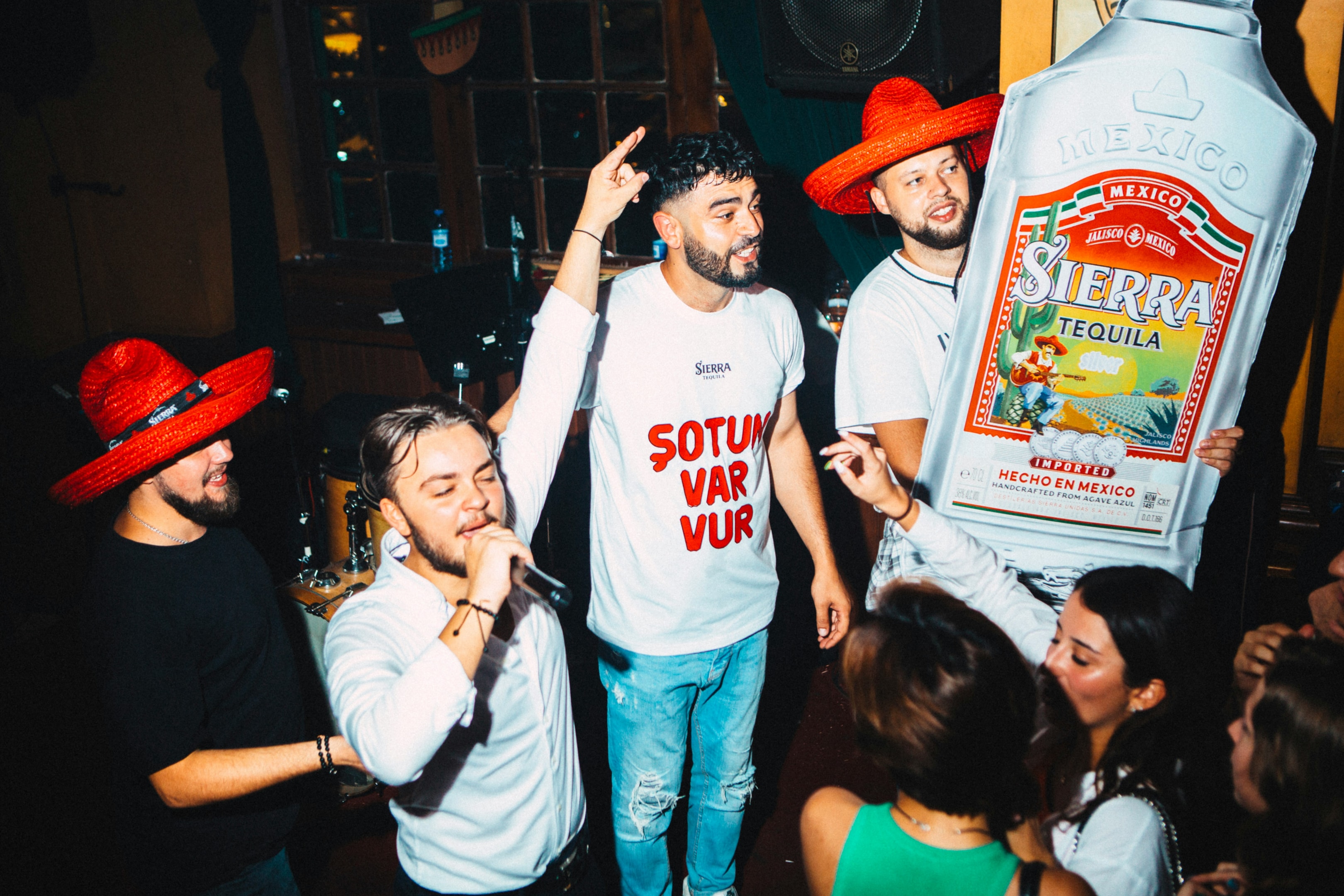people partying with giant bottle of liquor