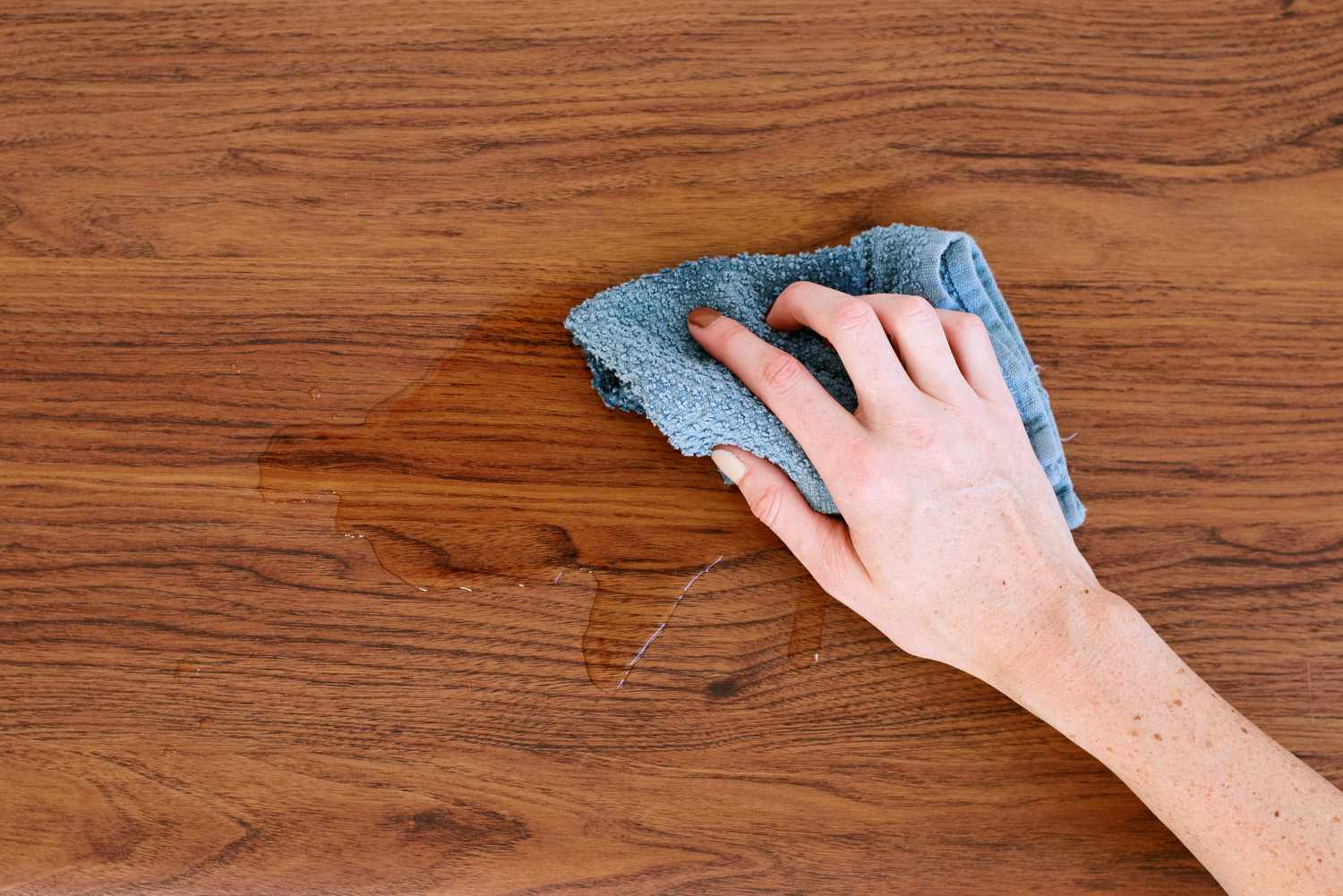 Wipe away liquid spills on the wood surface using a soft cloth