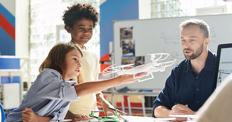 Students in a classroom exploring the future of aerospace, learning through drones and advanced aircraft that represent the next generation of innovation.