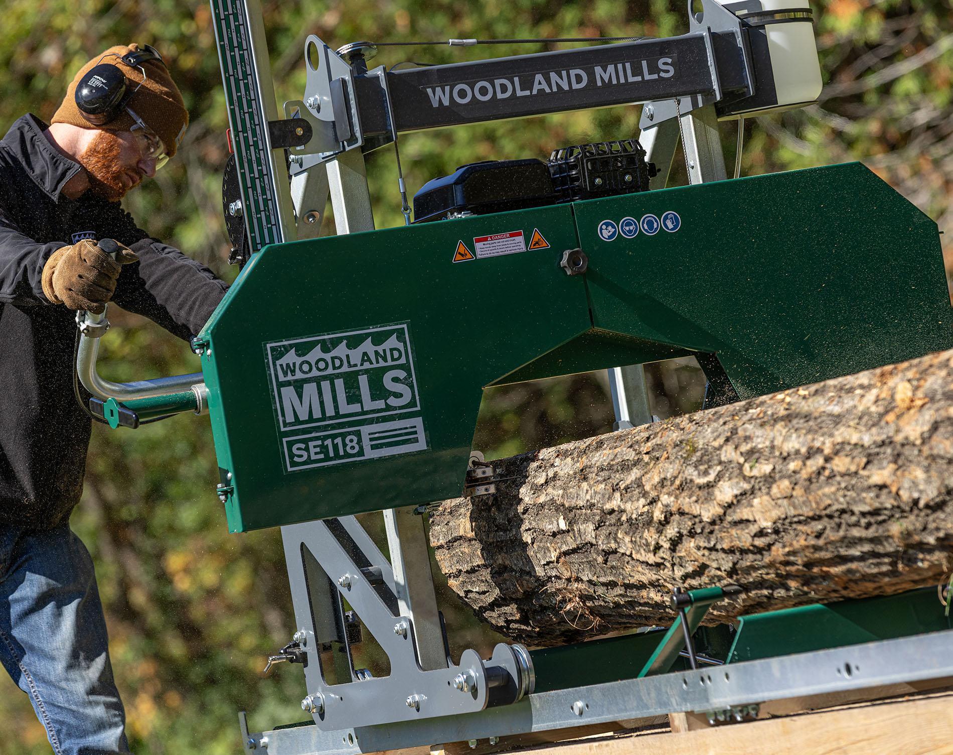 Une scierie portable Woodland Mills SE118 en train de découper des planches à partir d'une grume.
