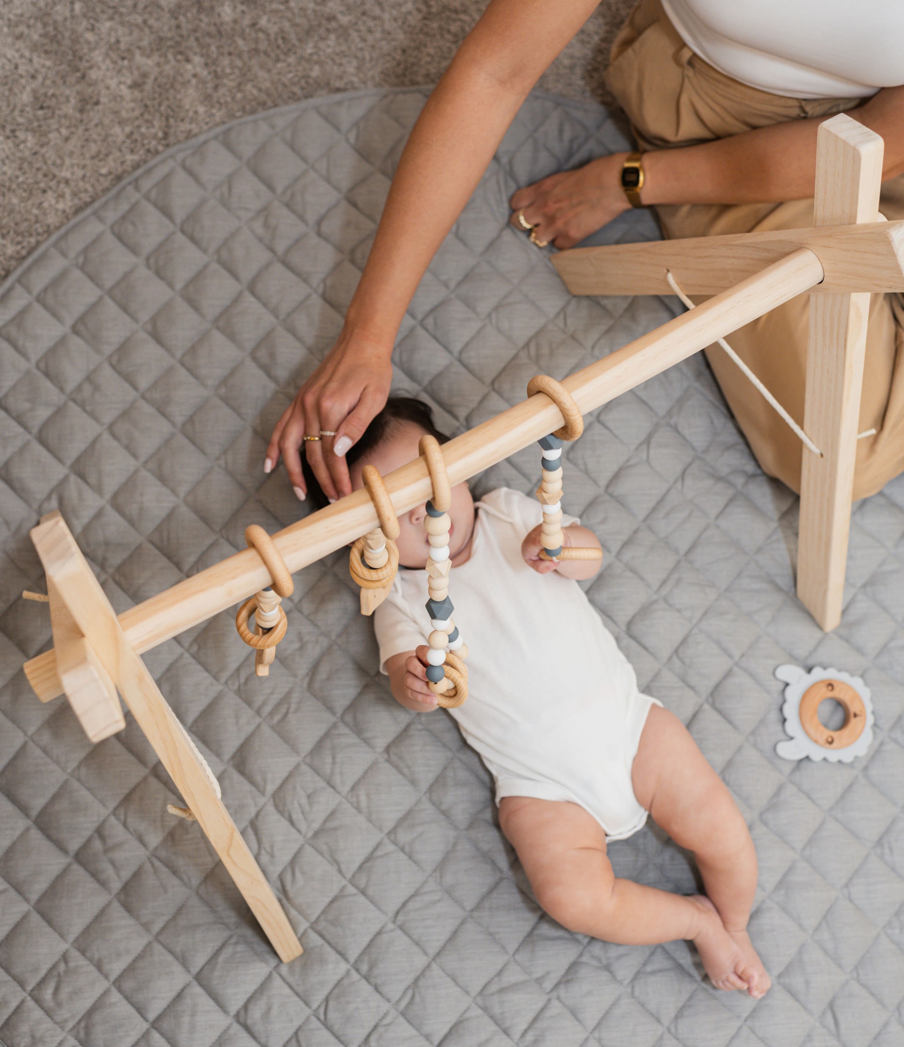 Baby doing Tummy Time on Play gym by Poppyseed Play