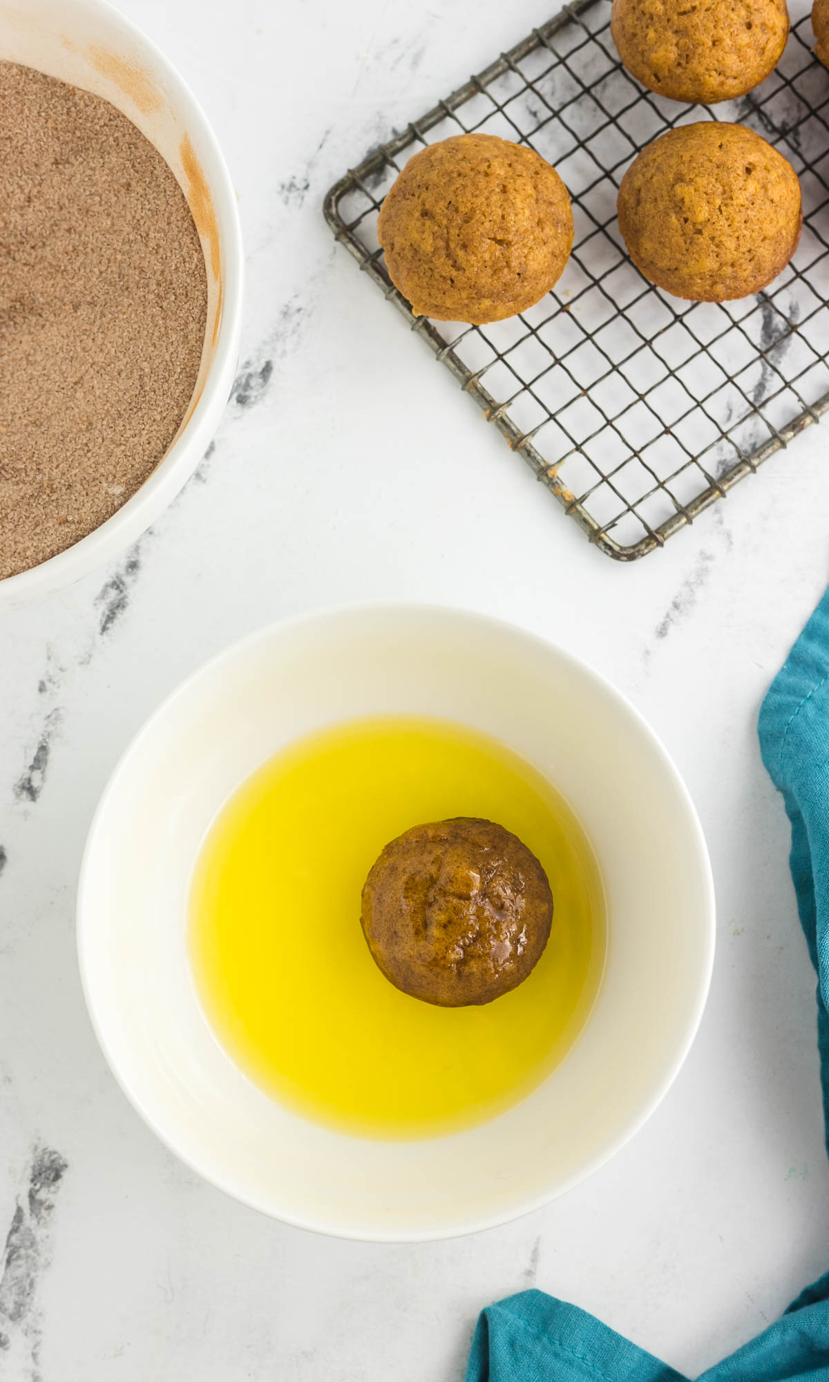 mini pumpkin muffin in a bowl of melted butter