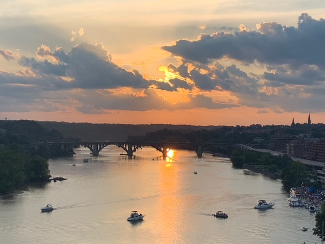 The sun setting over the Potomac River behind a bridge 