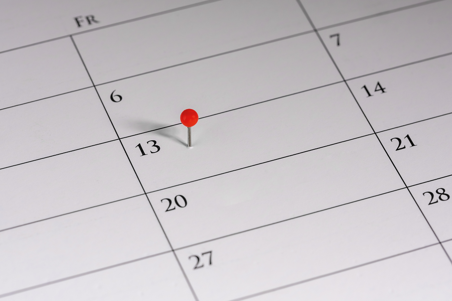 A calendar with a pin on the 13th date.