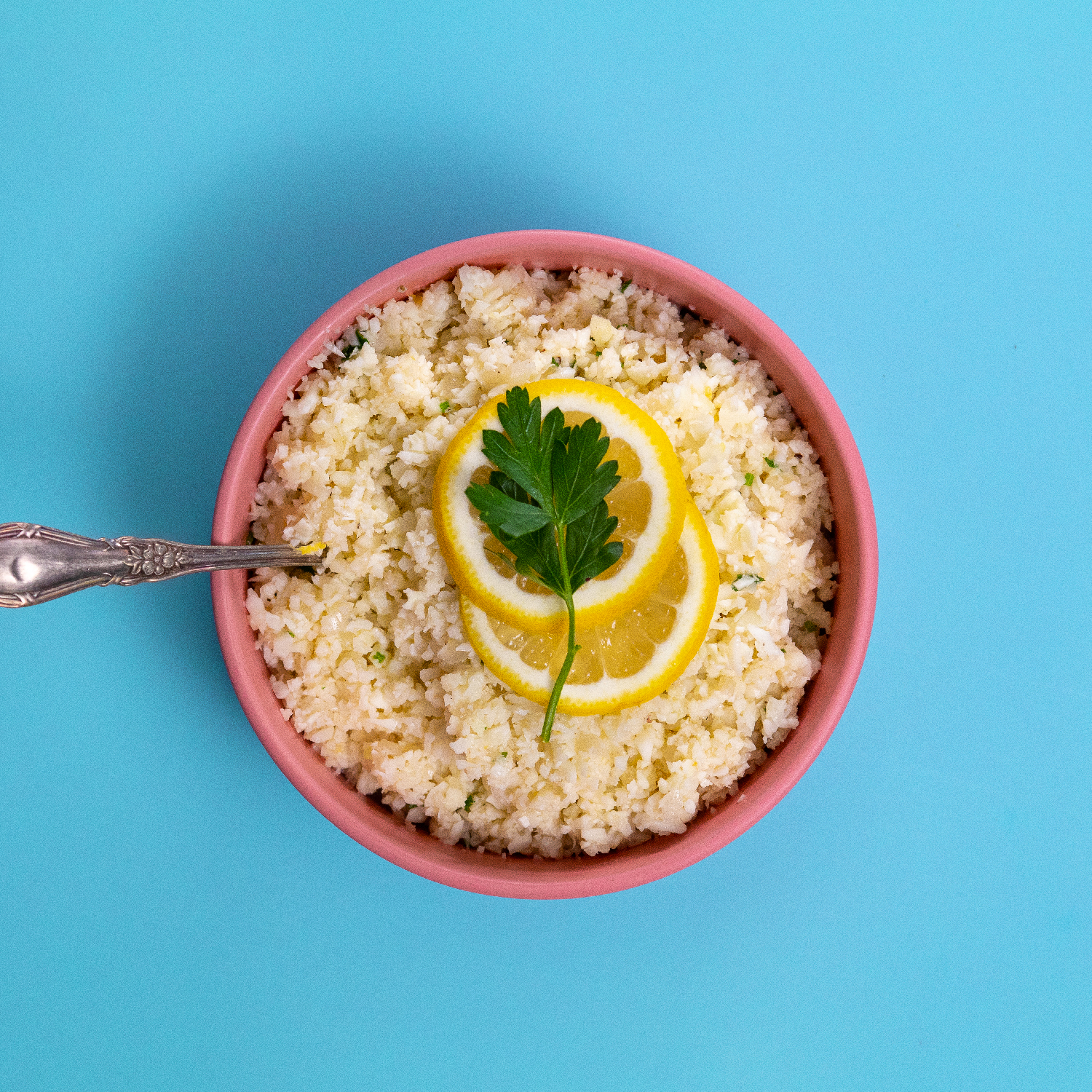 A bowl of Proper Good's Basmati Rice topped with lemon slices and cilantro