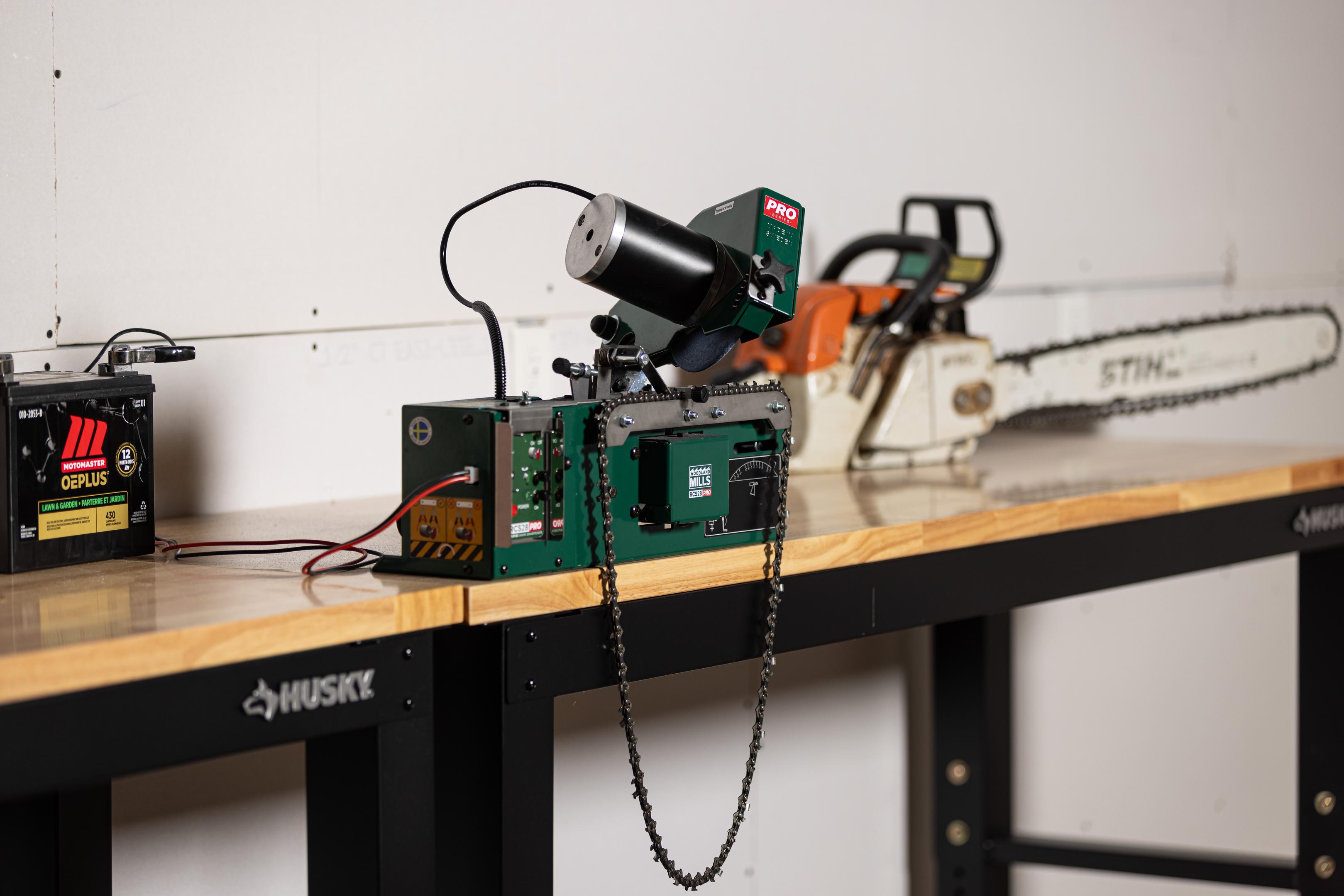 An RCS28 PRO Chainsaw Chain Sharpener on a work bench. 