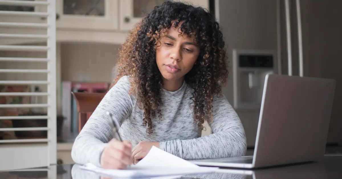 A woman filling out Form 1040-X for OnlyFans tax mistake correction.