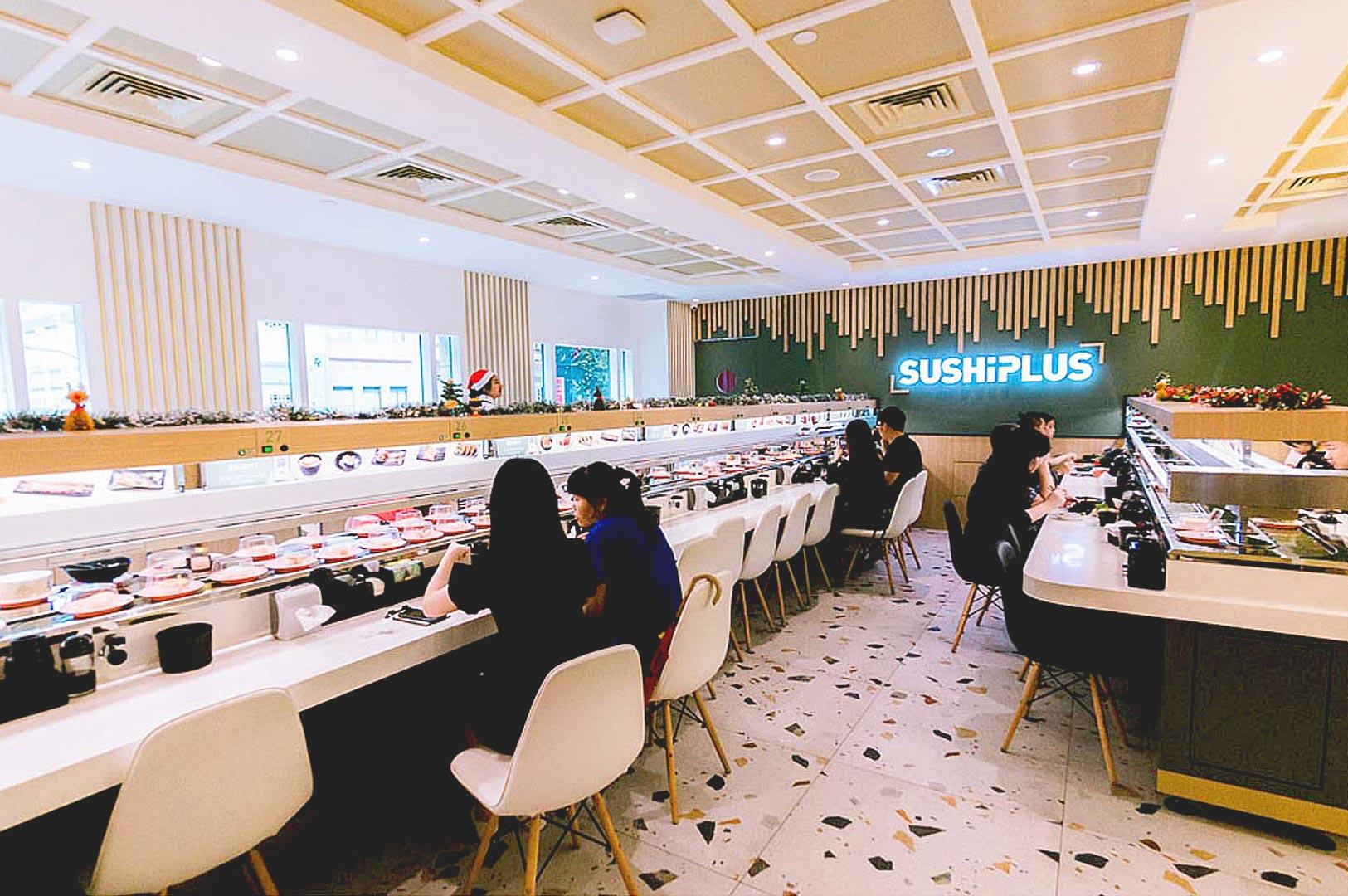 Diners enjoying conveyor belt sushi at Sushi Plus Singapore.