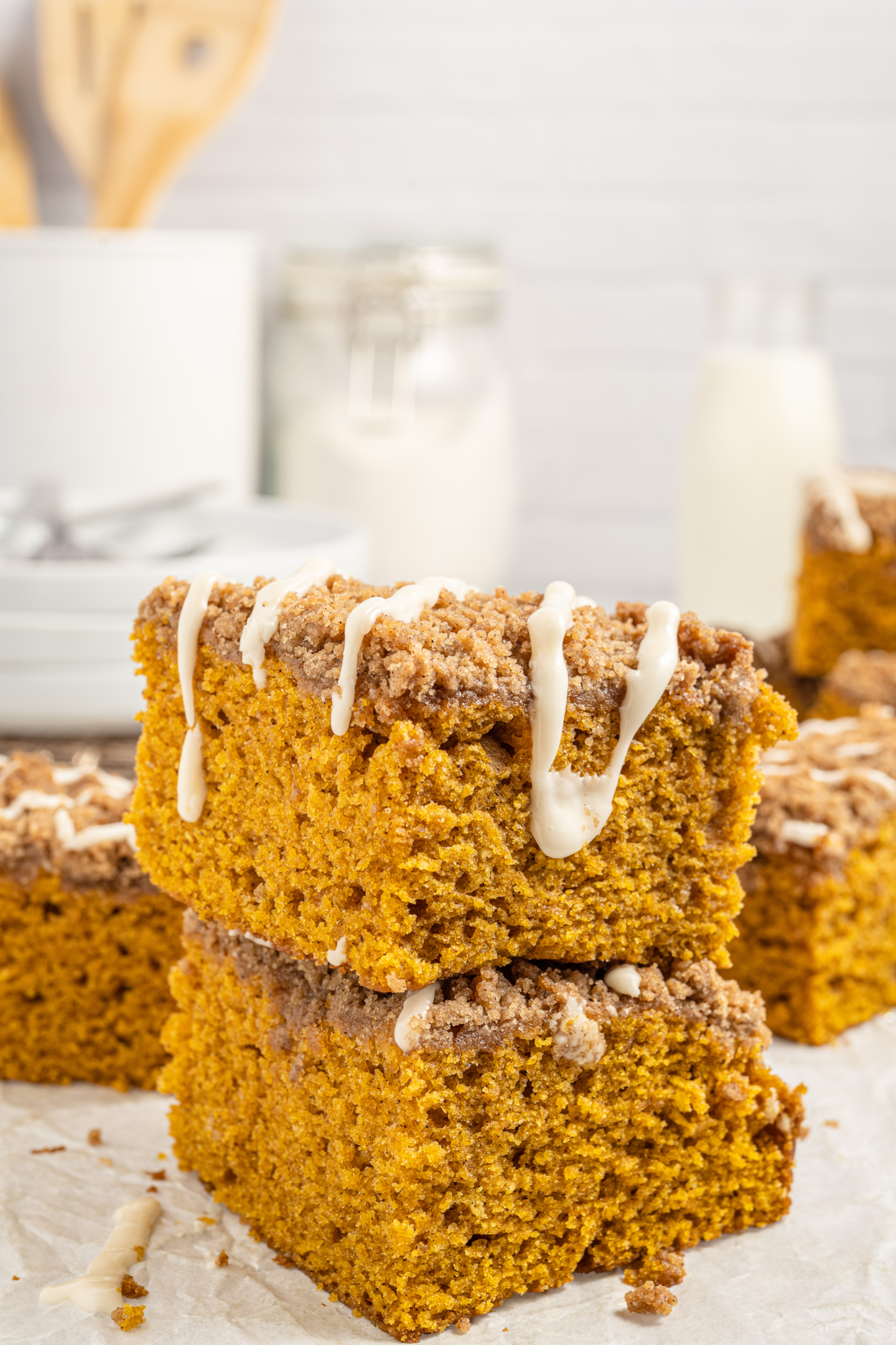 two slices of pumpkin coffee cake stacked on top of each other topped with brown sugar streusel