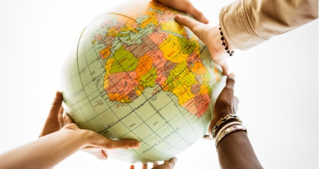 interracial students touching a globe