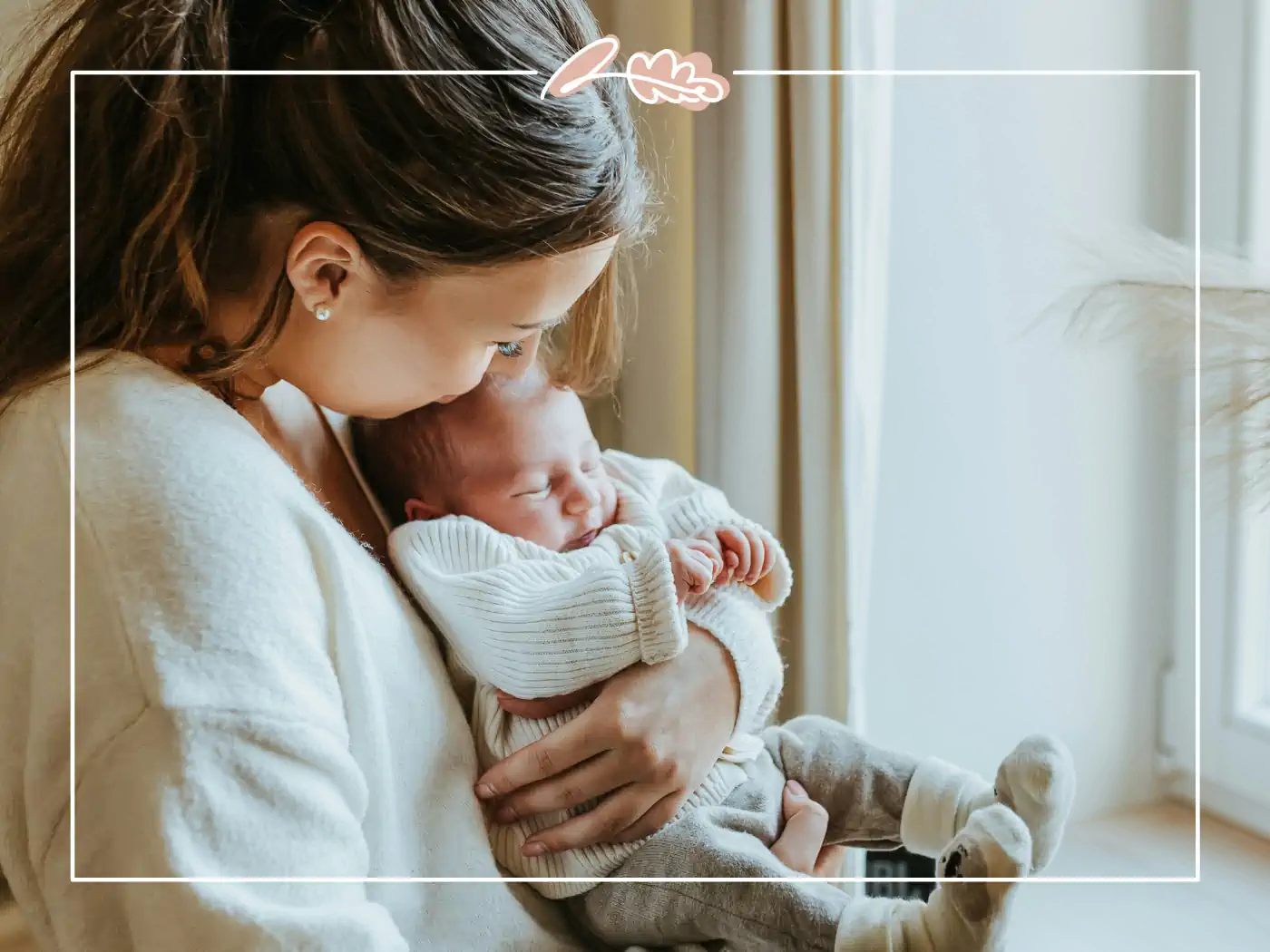 A mother holding her newborn baby, sharing a tender moment near a window. Fabulous Flowers and Gifts.