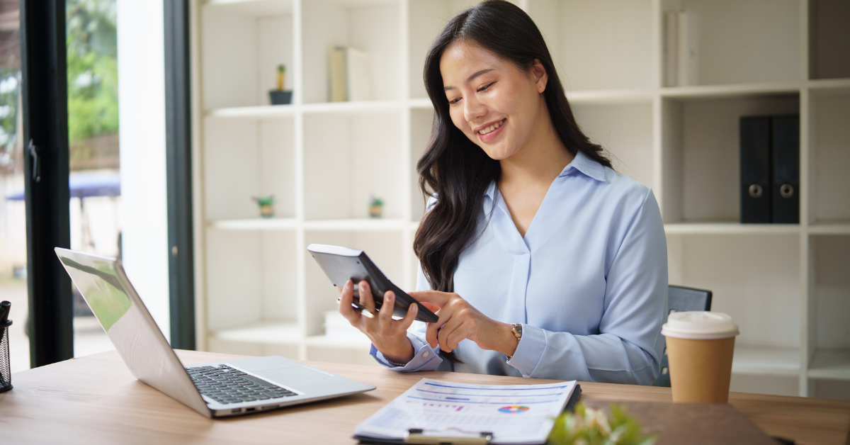 Woman reviewing her K1 tax form with calculator, preparing for her tax return.