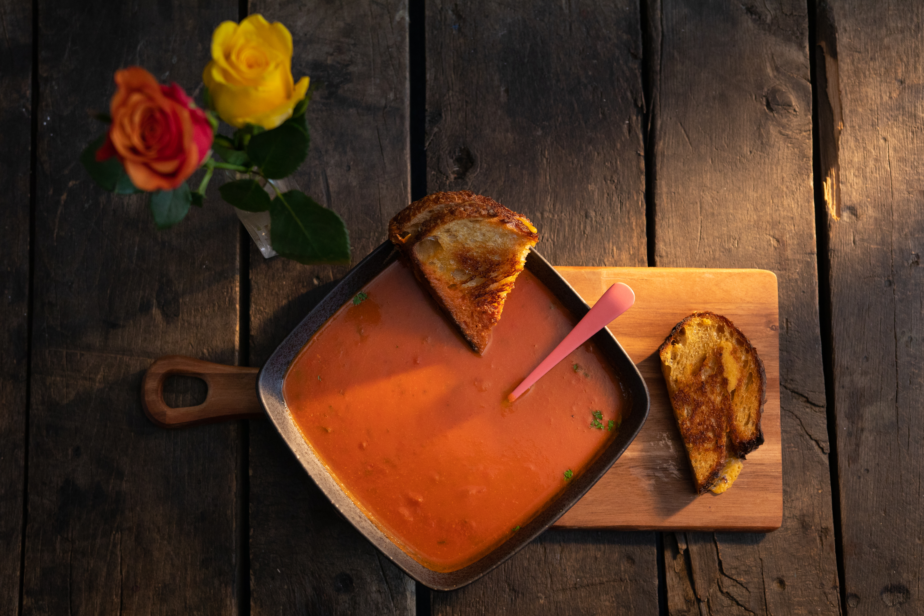 A bowl of creamy keto tomato soup topped with fresh basil leaves and a drizzle of olive oil