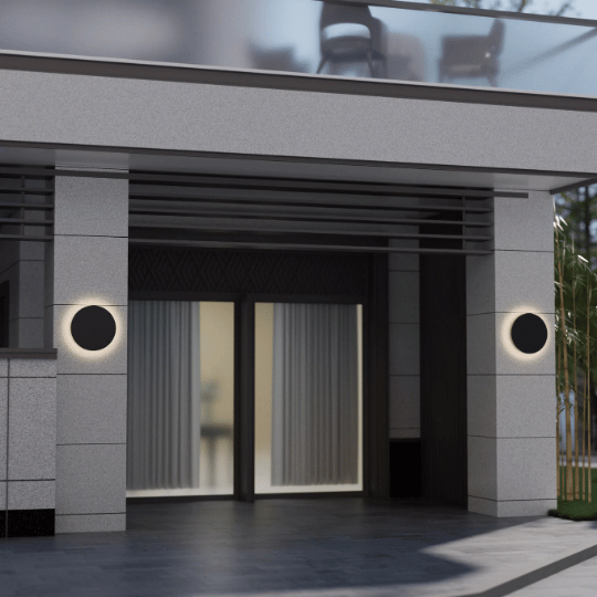 Modern building entrance with two circular wall lights emitting a soft halo glow on either side of sliding glass doors.