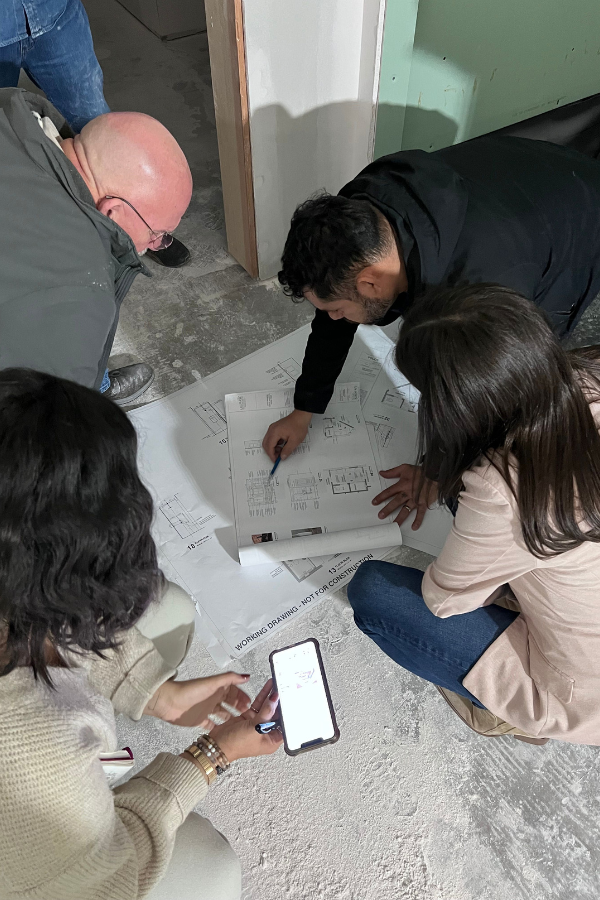 builders and design team members meet to discuss blueprints