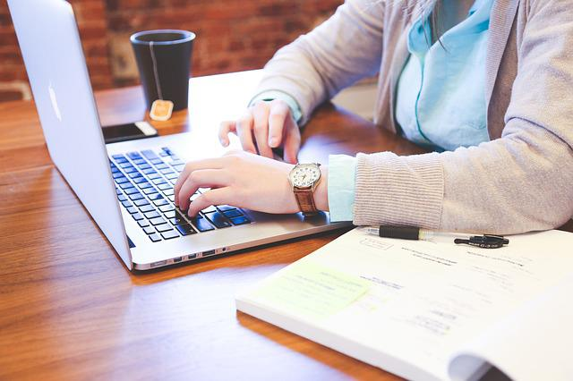 person type on a laptop with coffee