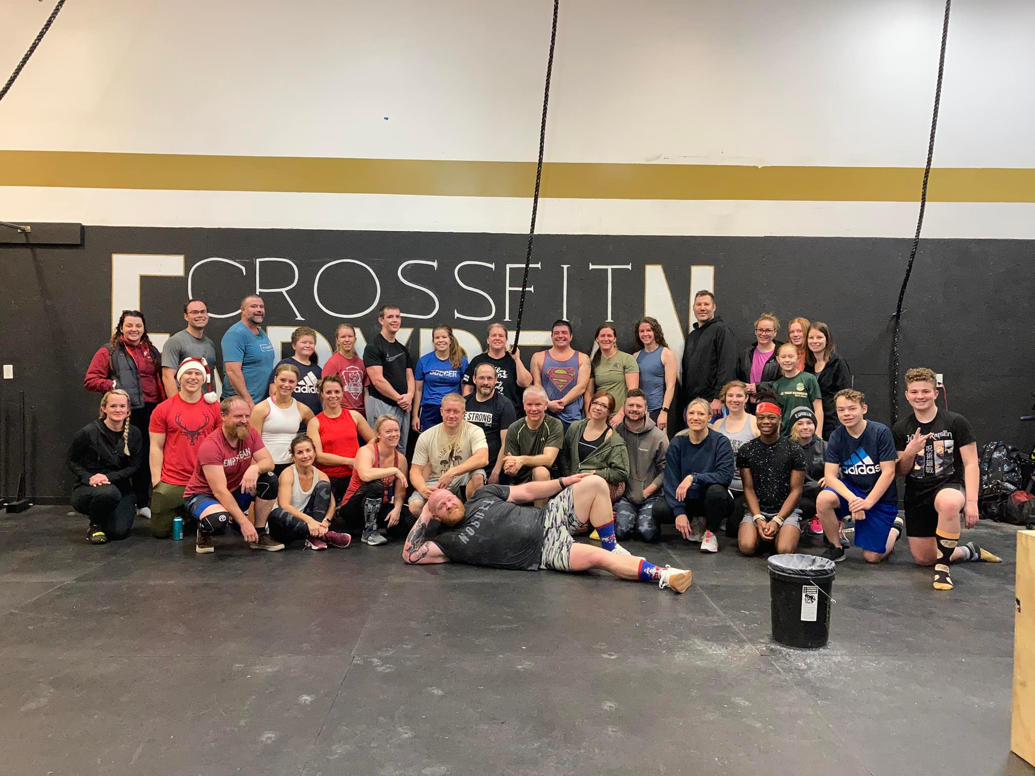 Group of people of different ages and skill levels doing CrossFit exercises in a gym, learning new skills and techniques