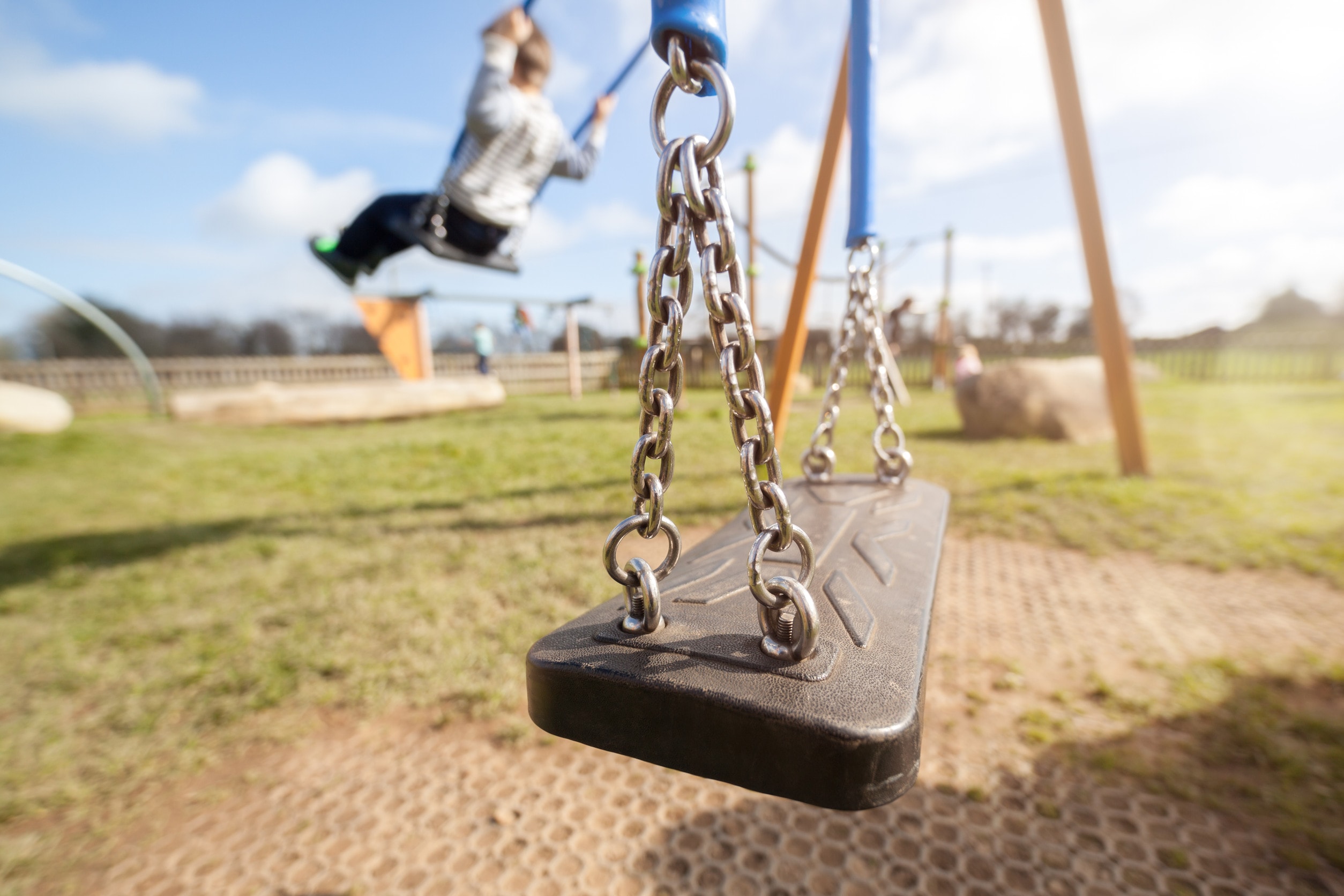A child playing on a swingset in a public park