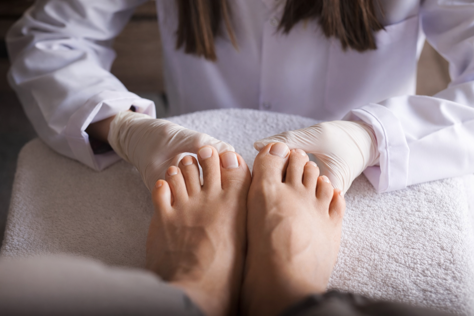 Foot doctor examining patient feet during clinic consultation