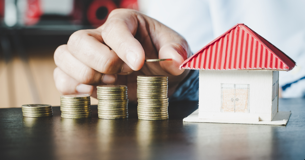 Rentvest - A person showing coins beside a dummy house