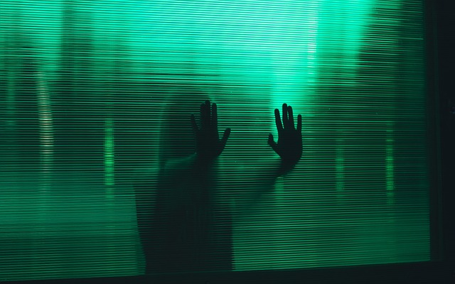woman with green background with hands up glass