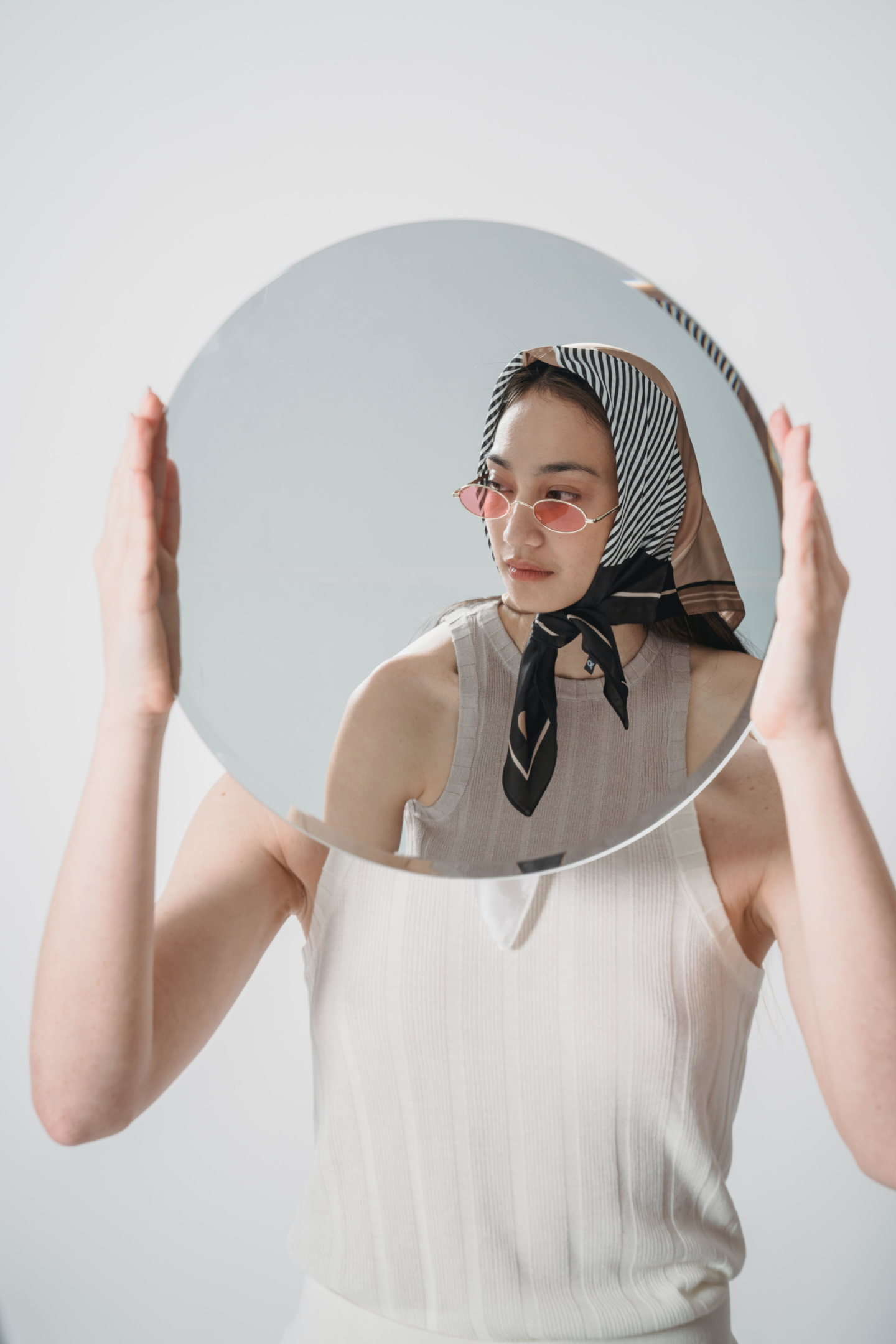 person holding up a mirror to represent the way you can focus on other factors than keyword stuffing in your product listings