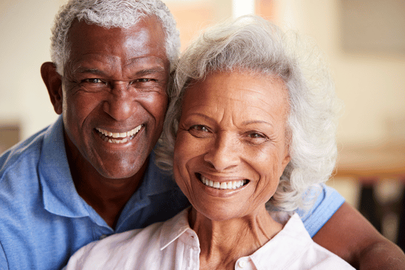smiling senior couple happy with the their tooth implants choice