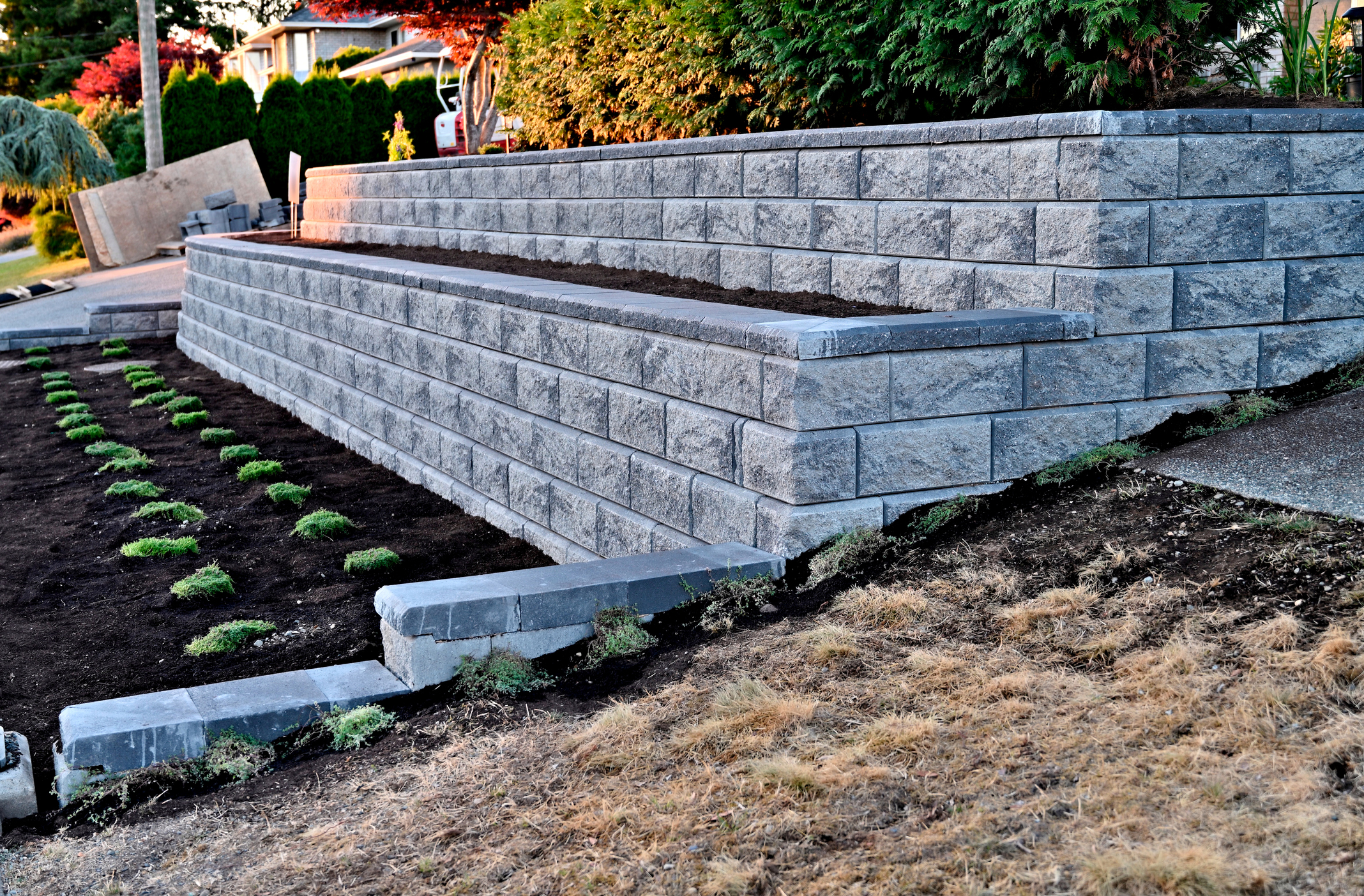 Interlocking concrete block retaining wall engineered with built in planters