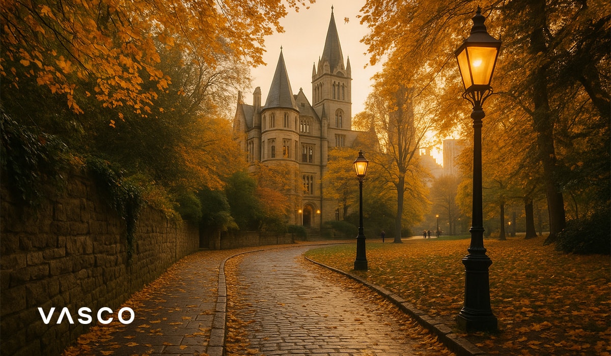 Chemin pavé menant à un château entouré d’arbres dorés d’automne.