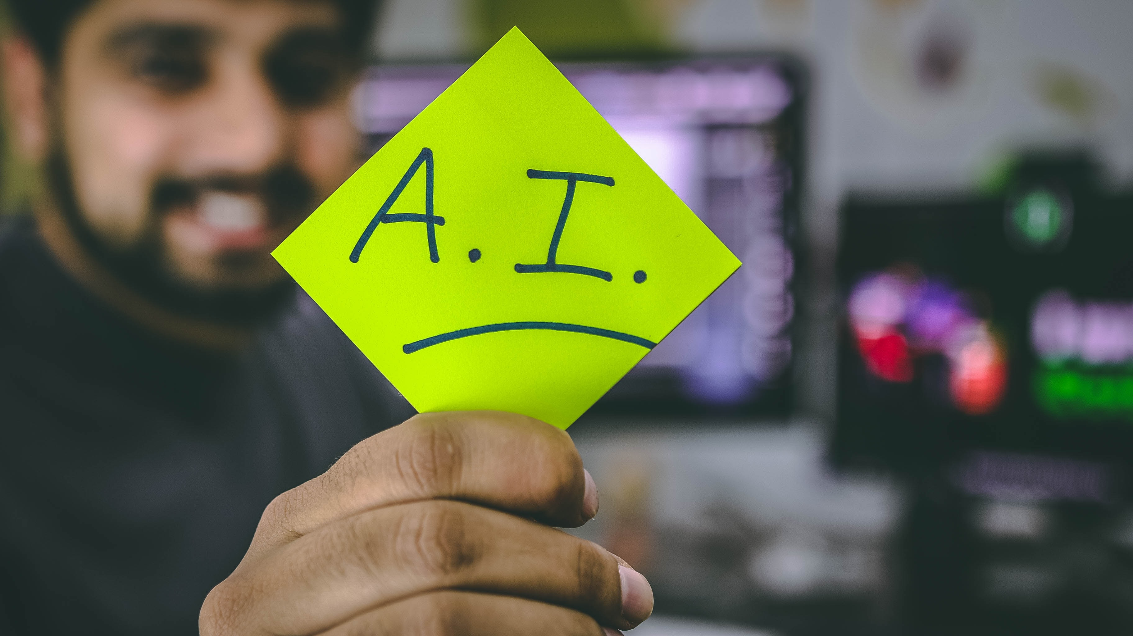 A person holding a paper with A.I. word on it.