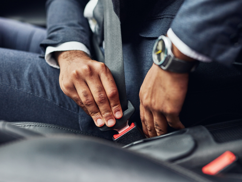 Image of a person buckling a seatbelt.