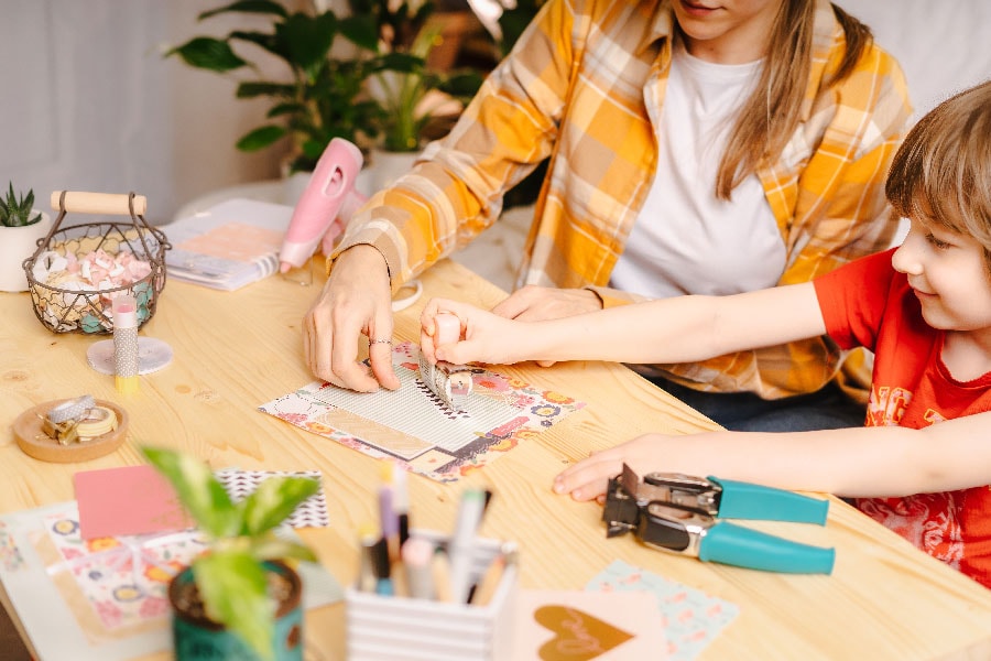 Scrapbooking with kid Freelance woman working from home. Homemade and crafts.