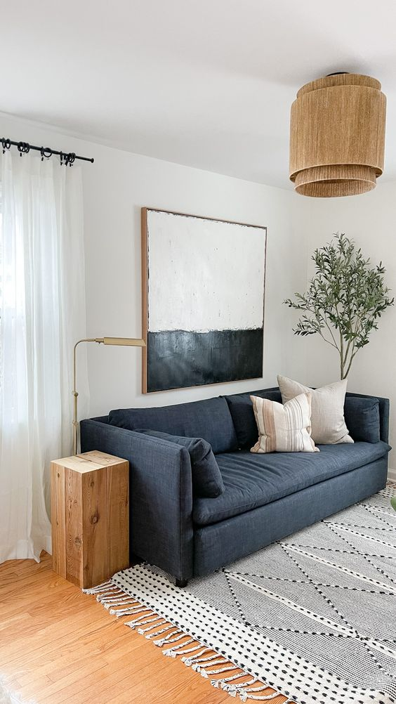 Sofa warna navy yang bersanding dengan aksesori kayu, via Pinterest