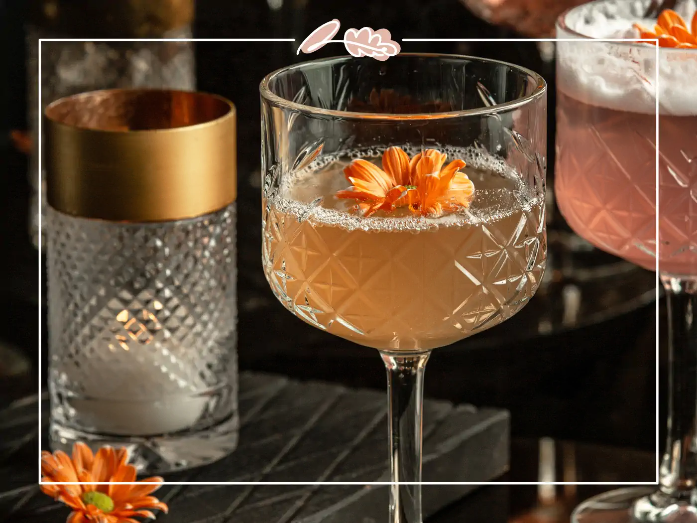 Elegant cocktail glass with a drink garnished with an edible orange flower. Fabulous Flowers and Gifts.
