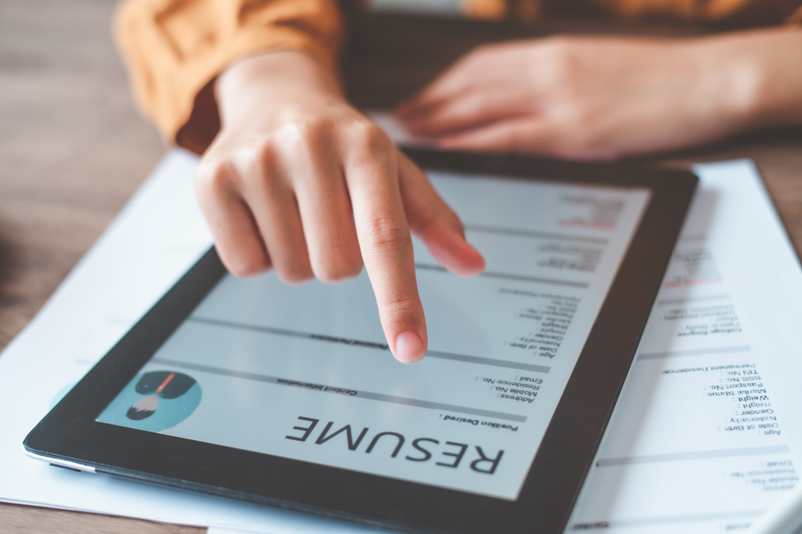 HR recruiter evaluating a digital resume on a tablet during a remote recruitment process