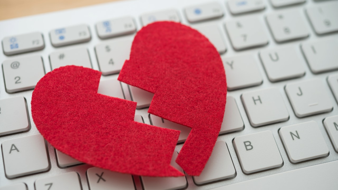 broken heart on computer keyboard, cybersecurity romance scam