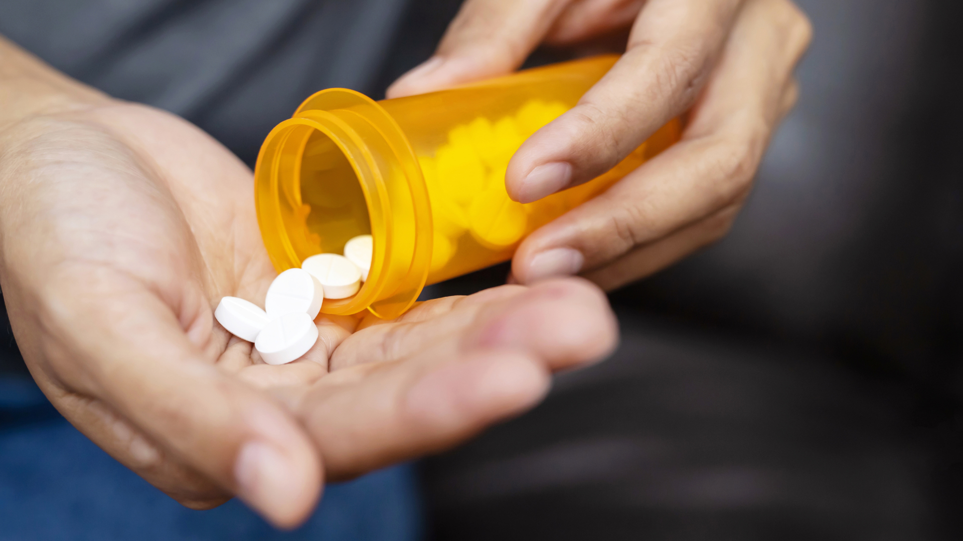 person pouring medication into their hands