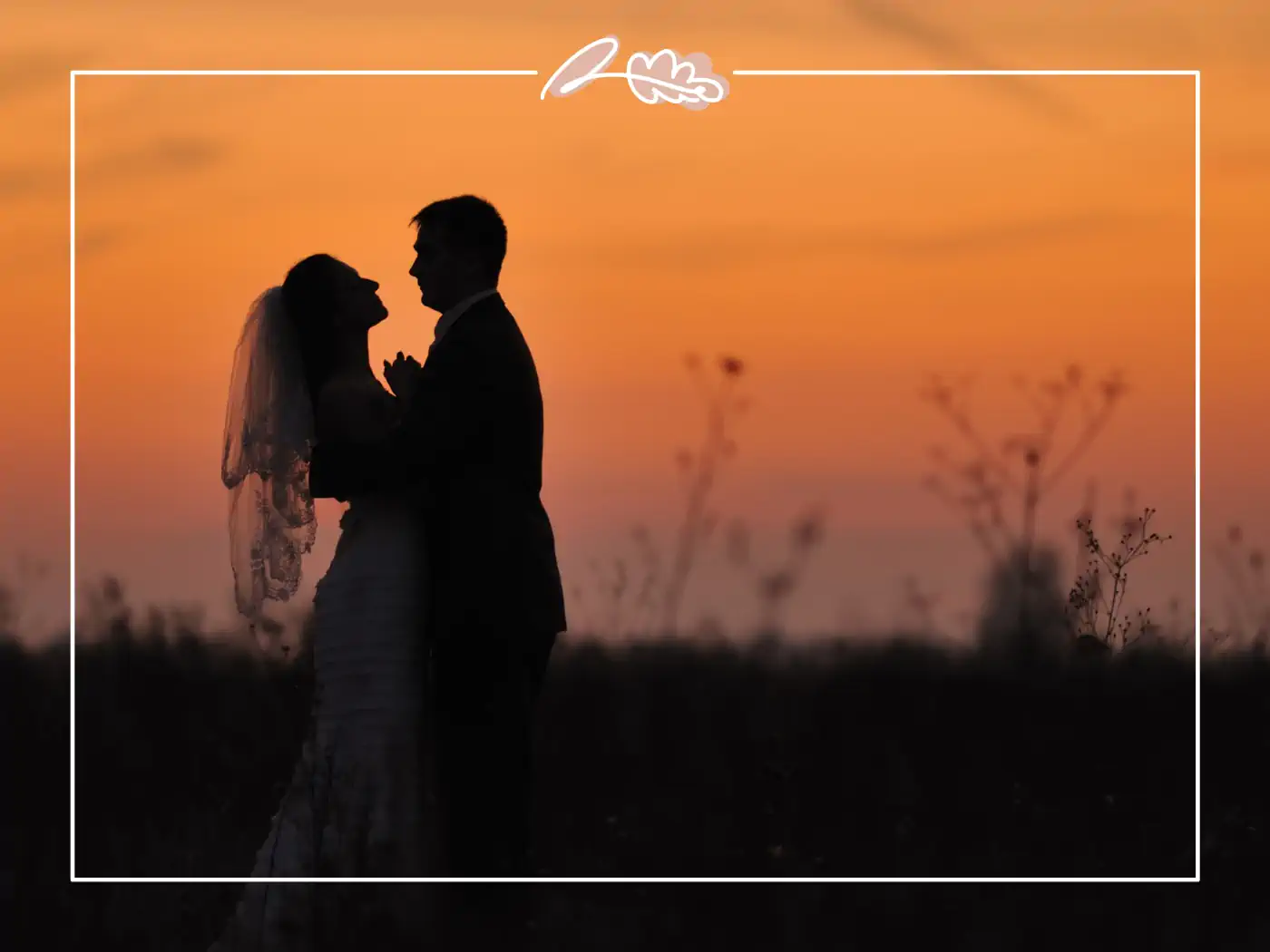 Silhouette of a bride and groom embracing against a stunning sunset backdrop. Fabulous Flowers & Gifts