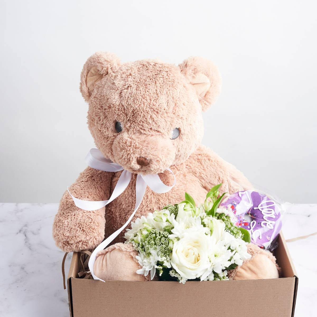useful gift for gender neutral baby, gender reveal gift, teddy bear with doughnut and white flowers